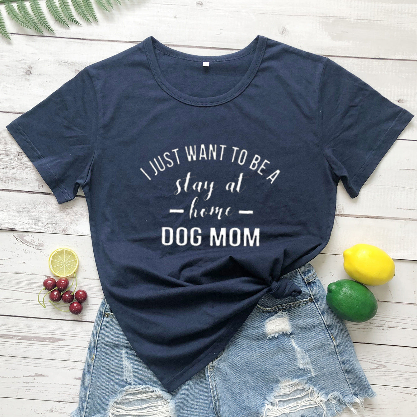 White T-shirt with black text saying "I Just Want To Be A Stay At Home Dog Mom" by PAWSOME PETS, casual and comfortable fit.