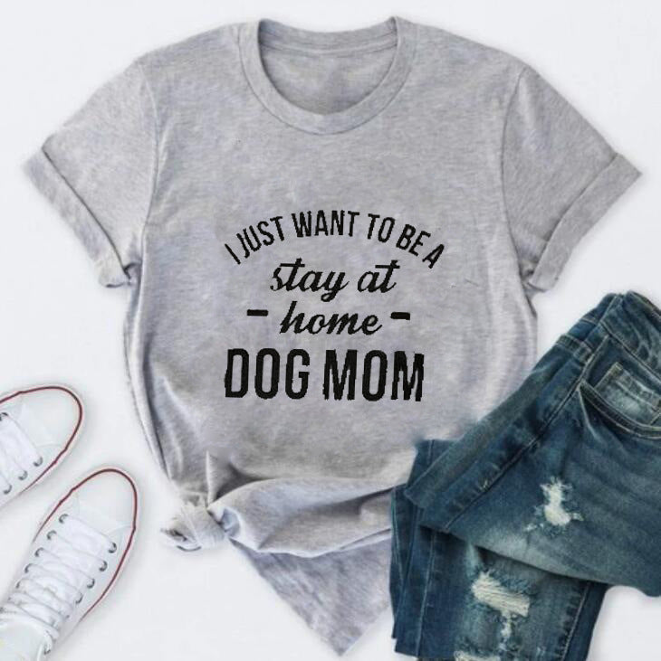 Pink T-shirt with "I Just Want To Be A Stay At Home Dog Mom" slogan and paw print design, by PAWSOME PETS.