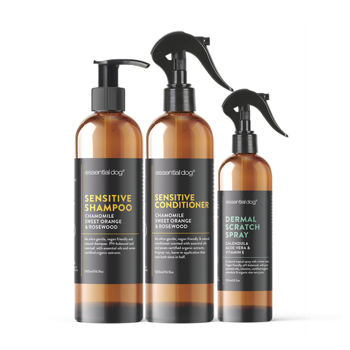 Essential Dog sensitive skin dog shampoo, conditioner, and dermal scratch spray shown in a natural setting for skin care.